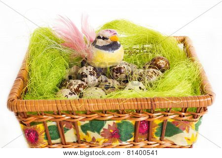 A little bird sitting in a nest with Easter quail eggs