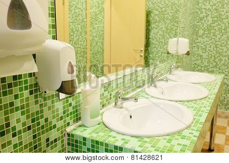 Public empty restroom with washstands and mirror