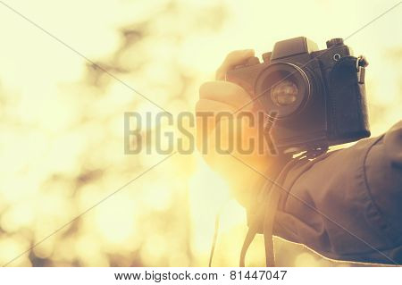 Man hand holding retro photo camera outdoor hipster Lifestyle