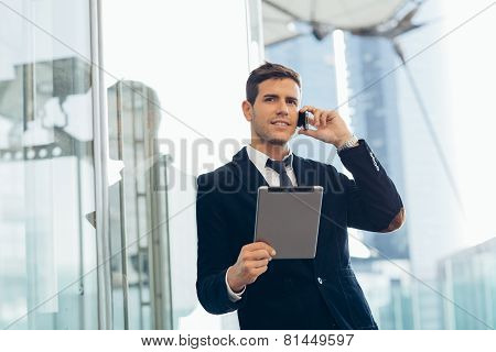Businessman using a mobile phone and digital tablet