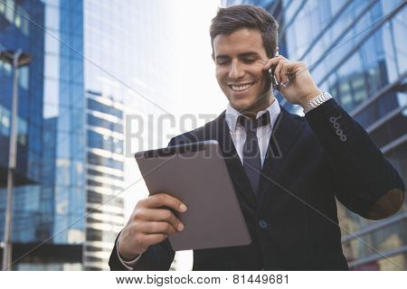Businessman using a mobile phone and digital tablet