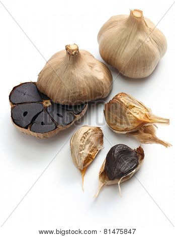 black garlic bulbs and cloves on white background