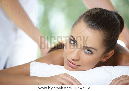 Hermosa mujer descanse sobre la cama de Spa
