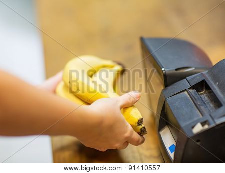 sale, shopping, payment, consumerism and people concept - close up of hands buying or scanning bananas at checkout in food market or mall