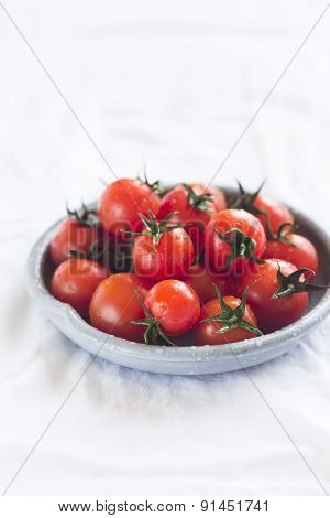 Cherry Tomatoes On A White Surface On A Vintage Plate