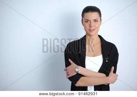 A young woman standing, isolated on graybackground