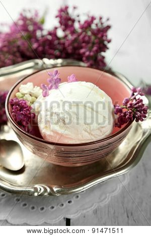 Beautiful composition with tasty ice cream and lilac flowers