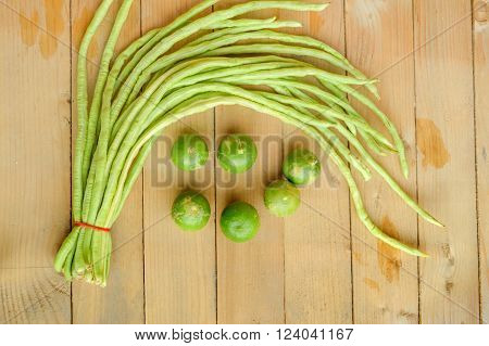 green lime and green yardlong bean on wood floor