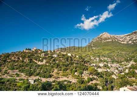 Beautiful view of a small mountain village Deia in Mallorca, Spain. Houses built on hills in Deia mountain village in Majorca island, Spain.