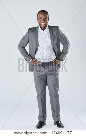 Full length portrait of approachable smiling black  professional in business suit isolated in studio