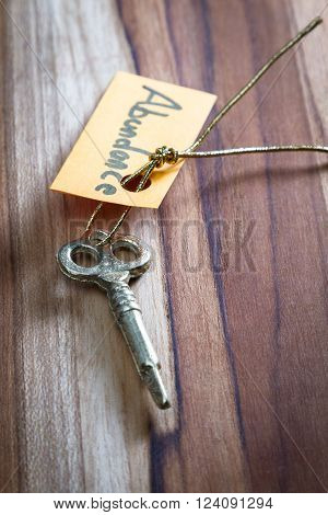 concept for a happy abundant life using an old decorative key and a hand written tag attached by a golden cord