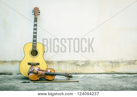 Acoustic guitar with violin vintage style old wall background