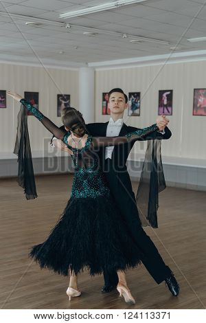 Professional dancers dancing in ballroom. Young couple