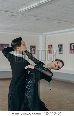 Professional dancers dancing in ballroom. Young couple