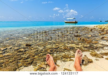 Sailor has a rest on a coral beach, Maldives