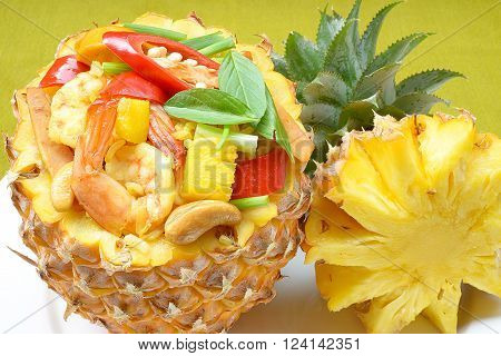 Freshly prepared pineapple fried rice served inside of a pineapple carved like a bowl.