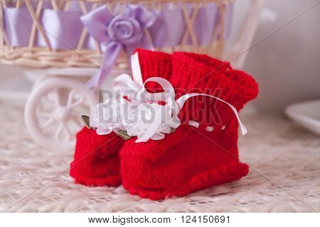 Pair of sweet red baby knitted booties with silk ribbons and roses