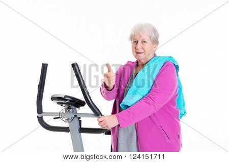 Female Senior With Thumb Up Train With Fitness Machine