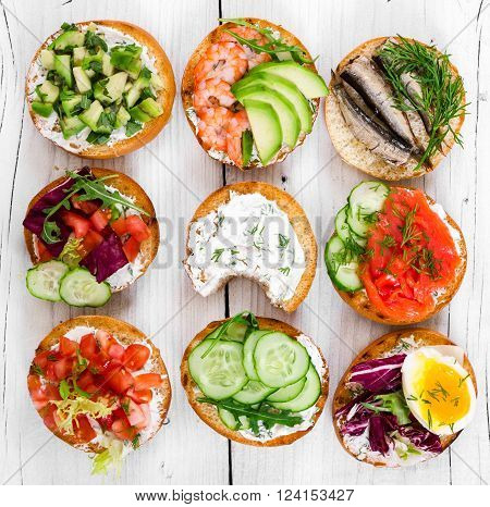 Small sandwiches on wooden rustic background top view.