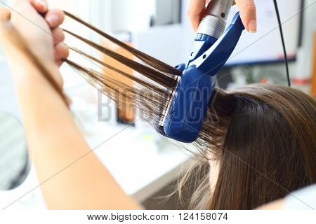 Straightener. Hairdresser hairstyle beautiful model using straightener.