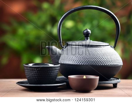 Black pialats and teapot on blurred background