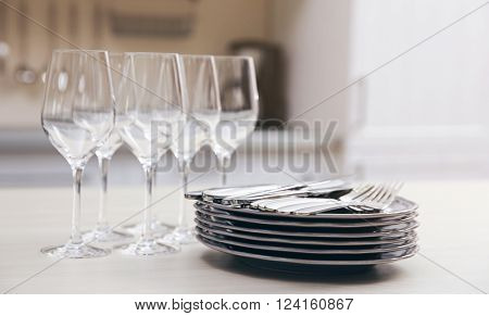 Prepared clean dishes for dinner party on a table in the kitchen