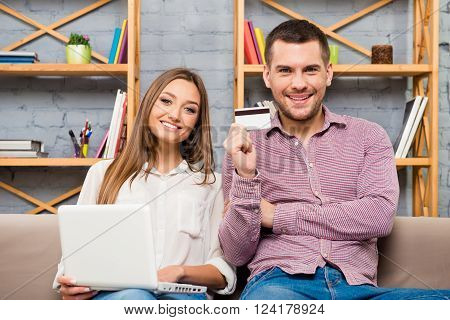 Man And Woman Making Internet Shopping With Laptop And Bank Card
