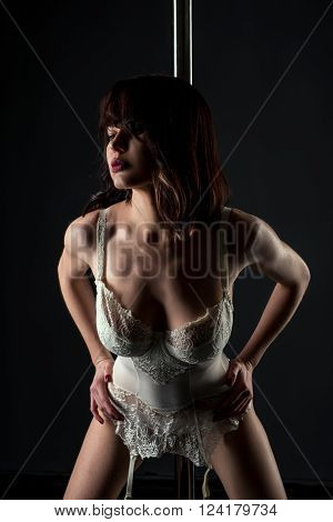 Studio photo of sexy stripper in lace corset with garters