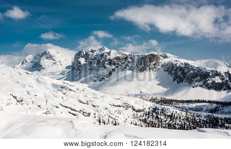 Winter panorama with snow covered slopes and dramatic sky. Komna, Slovenia.