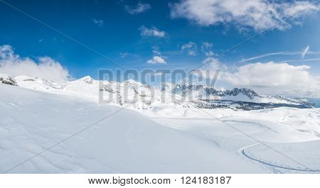 Winter panorama with snow covered slopes and dramatic sky. Komna, Slovenia.