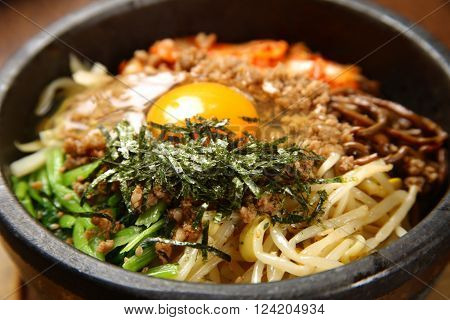 close up shot of bibimbap in a stone bowl