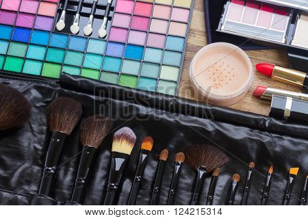 Set of  black brushes, lipsticks, maskara, eye shadows and  powder, top view