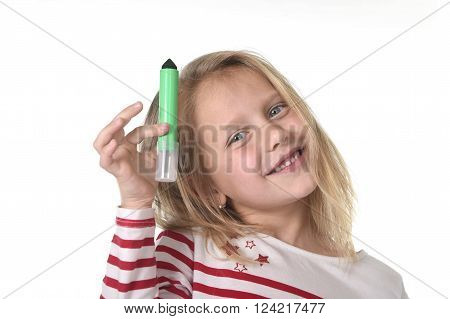 sweet beautiful female child 6 to 8 years old with blonde hair and blue eyes holding drawing - writing marker isolated on white background in education and primary or junior school supplies concept