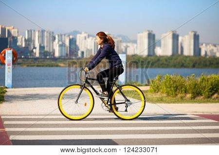SEOUL KOREA - APRIL 24 2015: A man cycling at a racreation park zone on the bank of Hangang river in Seoul Korea