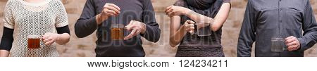 four people with teaglasses are sharing a teabag, concept food sharing or share economy