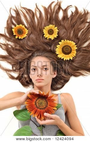 Junge schöne Brünette Frau mit langen Haaren zerstreuten und Sonnenblume