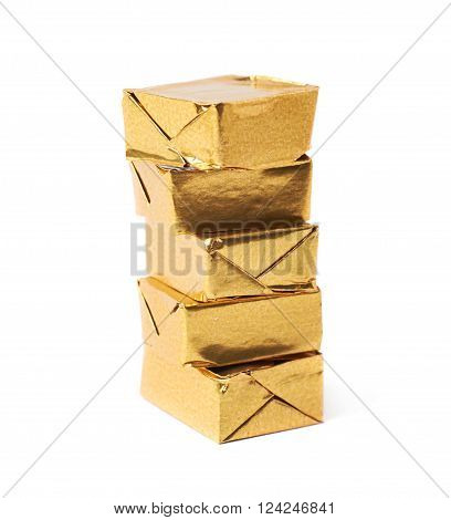 Stack of mulitple bouillon stock broth cubes wrapped in golden foil, composition isolated over the white background
** Note: Shallow depth of field