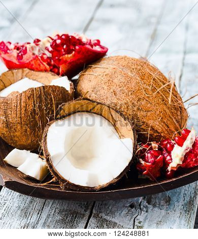 Fresh Coconut And Red Garnet In A Wooden Bowl,blue Background