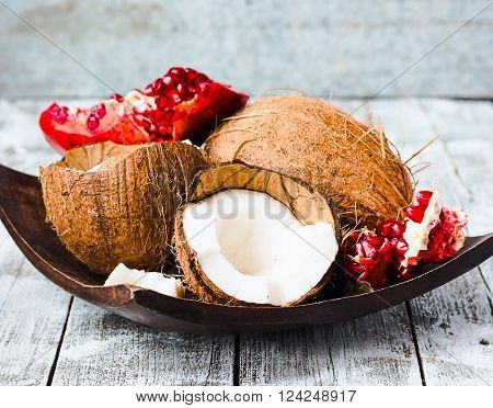 Fresh Coconut And Red Garnet In A Wooden Bowl,blue Background
