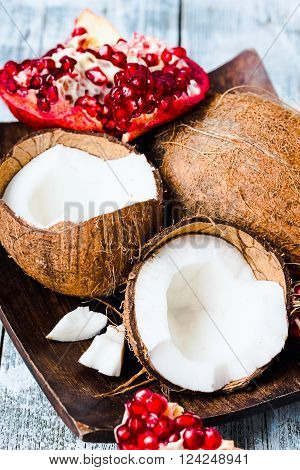 Fresh Coconut And Red Garnet In A Wooden Bowl,blue Background