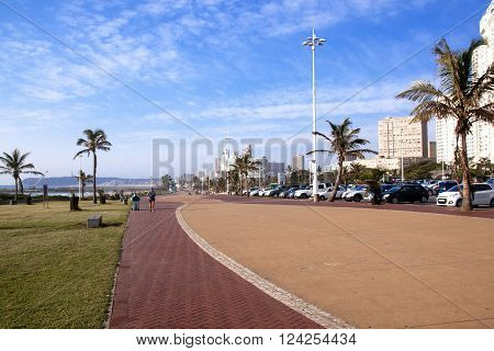 DURBAN SOUTH AFRICA : APRIL 1 2016: Many unknown people on early morning beach front against city skyline in Durban South Africa