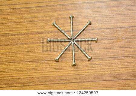 The salf tapping screw on wood background.