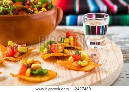 Close up of nachos chips and tequila with a poncho on background
** Note: Shallow depth of field