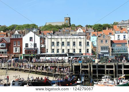 SOUTH BAY HARBOR, SCARBOROUGH, NORTH YORKSHIRE, ENGLAND - 19th of May 2014: Tourists enjoying a day out in the popular seaside resort of Scarborough, North Yorkshire, England