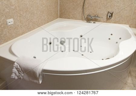 Interior design of a hotel bathroom, , whirpool bath. Hotel restroom interior design. Spa, hydromassage bathtub, . Bathroom interior design. Modern bathroom closeup of bath and towel.