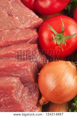 fresh raw beef with vegetables closeup, top view