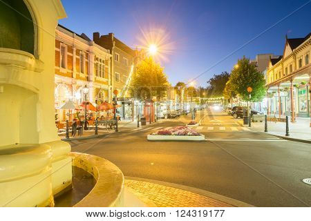 Wanganui, New Zealand - February 20, 2016: Wanganui, New Zealand - February 20, 2016: Night street scenes in city Wanganui historic and deco buildings around the light standard roundabout and light streaks of cars driving along Victoria Avenue through dow