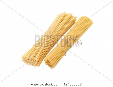 Two bundles of different uncooked dried long pasta on a light background