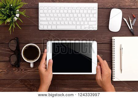 hand using white tablet on workspace top view