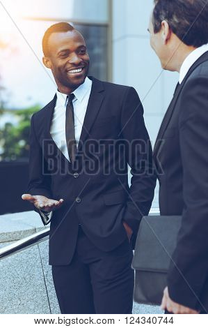 Talking about business. Two cheerful business men talking and gesturing while standing outdoors
** Note: Visible grain at 100%, best at smaller sizes